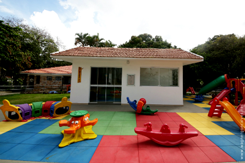 Imagem do espaço de lazer para hospedagem de crianças com necessidade de tratamento mostrando brinquedos como escorregador, balanço, tunel e mutitas outras brincadeiras com cores e espaço agradável.